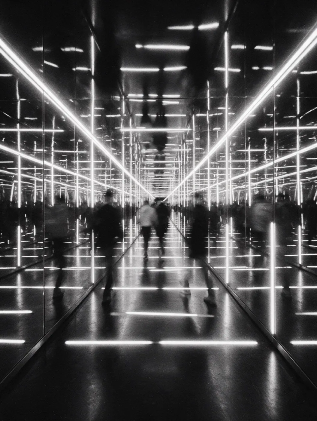 Visitors walking through a tunnel of lights and mirrors